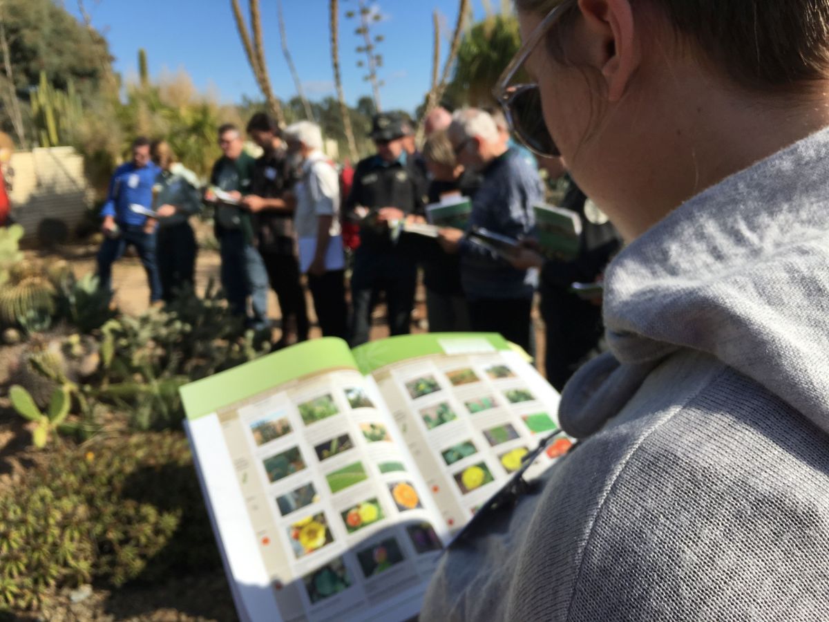 An image of a book and weed identification training by the Weeds at the Early Stage of Invasion (WESI) team