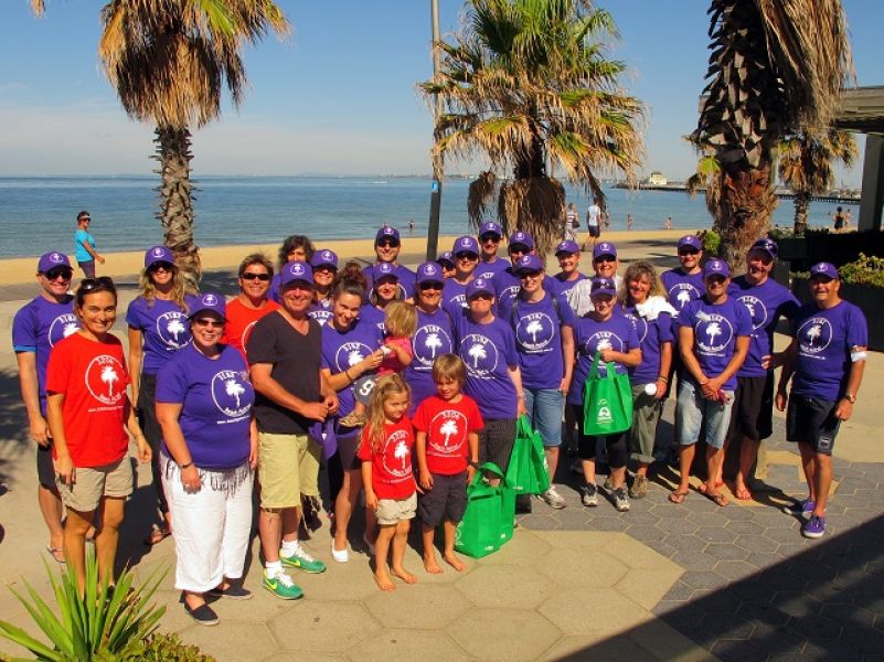 group of people holding full rubbish bags infront of St Kilda Beach