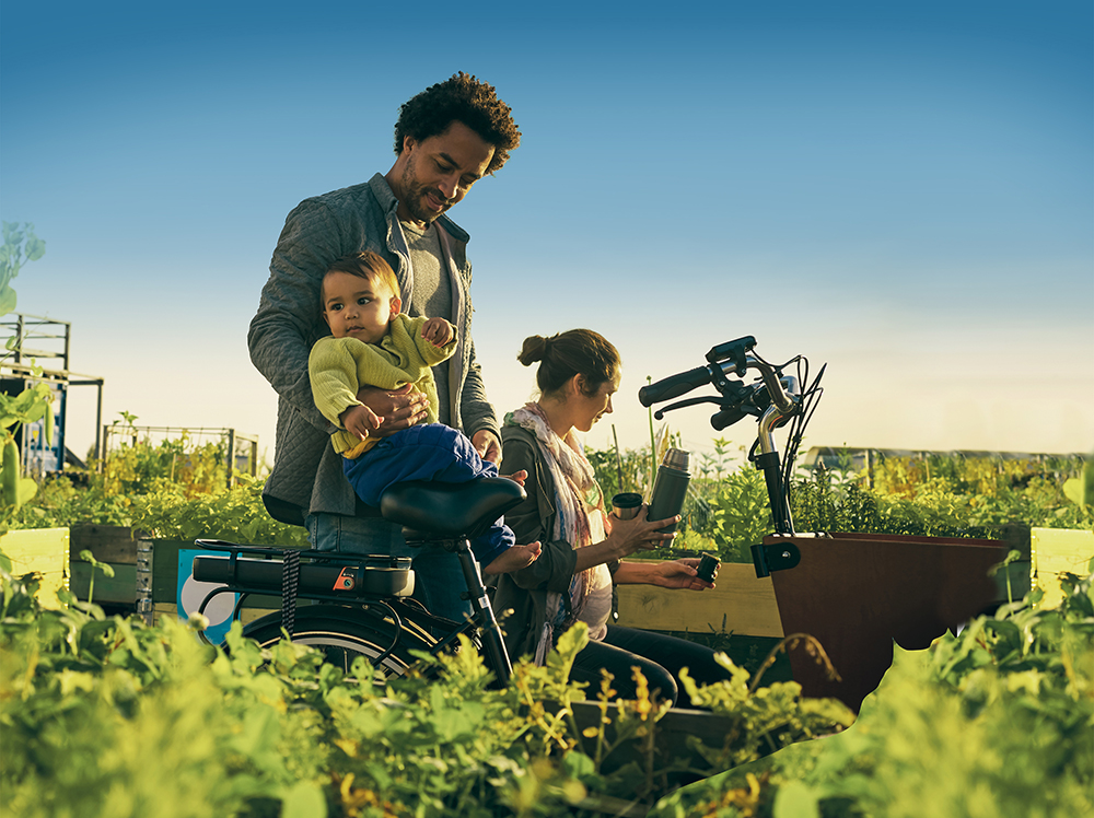 Family outside in a garden allotment with a cargo bike