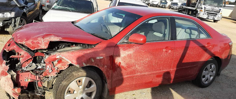 Photo of a red car with severe damage to the front end after hitting a deer.