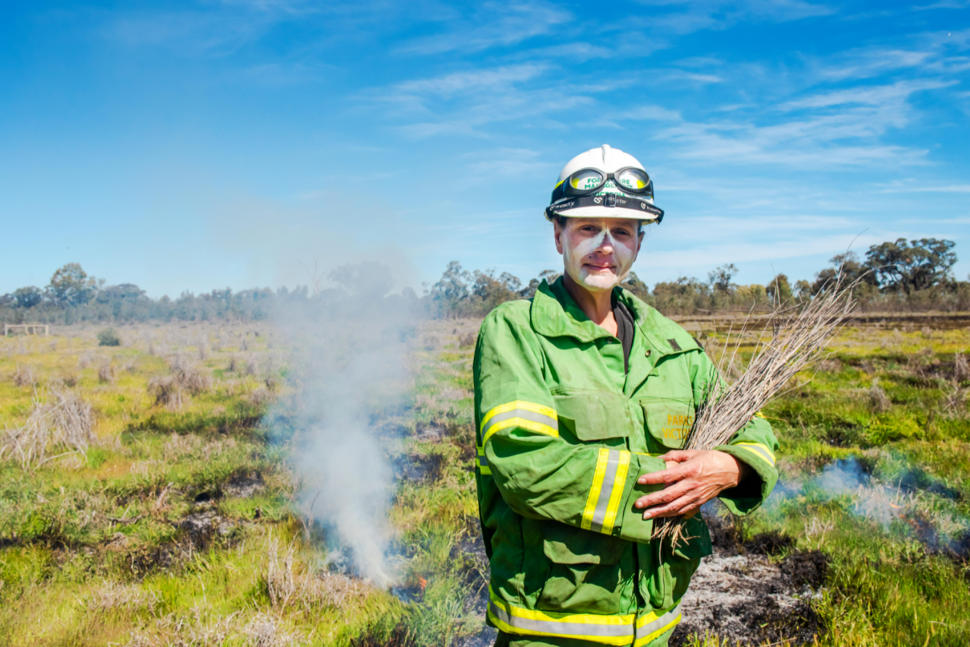 An indigenous woman undertaking a cultural burn.