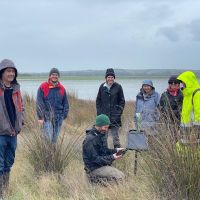 People standing in grasslands looking around