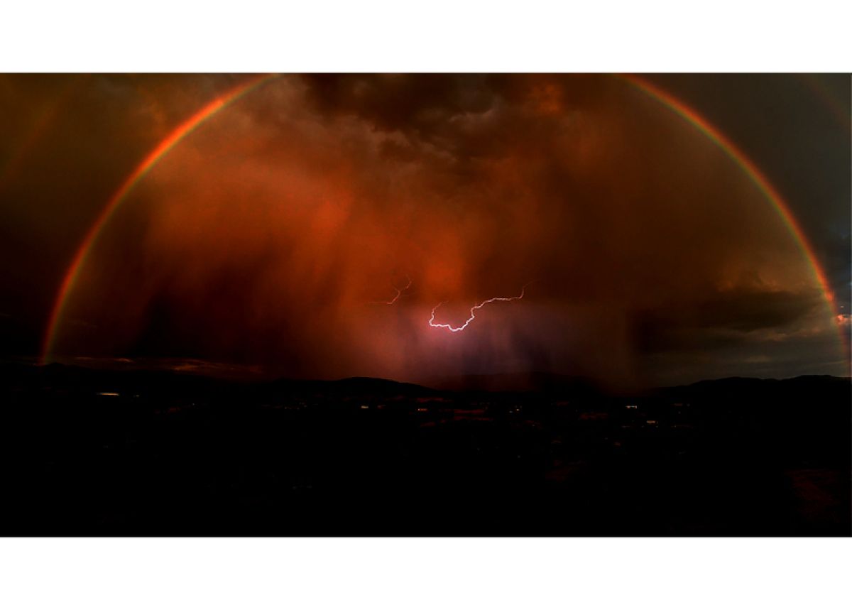lighting bolt inside a rainbow at night