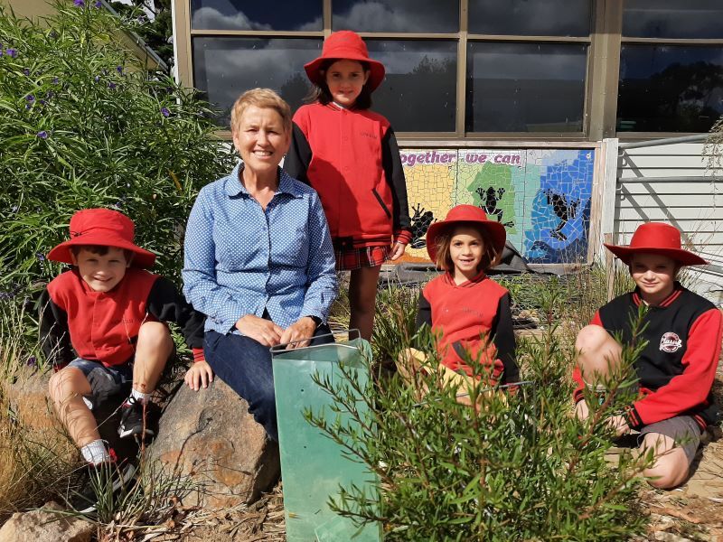 Teacher and children outdoors in a garden area