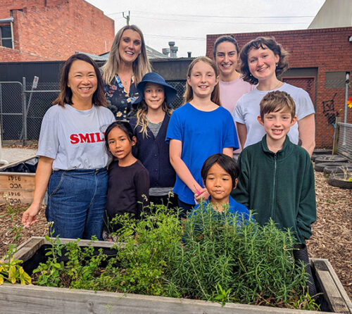 group of teachers and kids infront of veggie patch