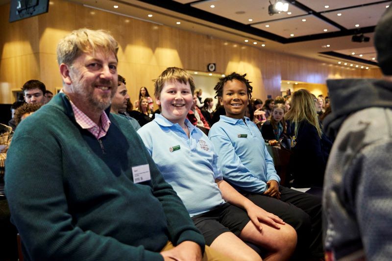 A group of people seated indoors at an event or conference